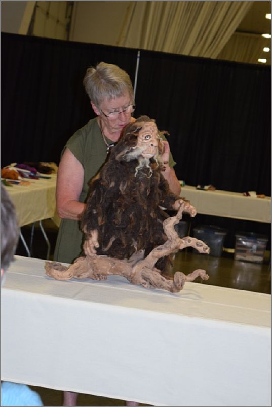 Judge Janet Potter evaluates Deborah Peterson�s needle-felted sculpture of Sasquatch which was awarded Reserve Champion for Best Felting entry. Photo: Peggy Lundquist.